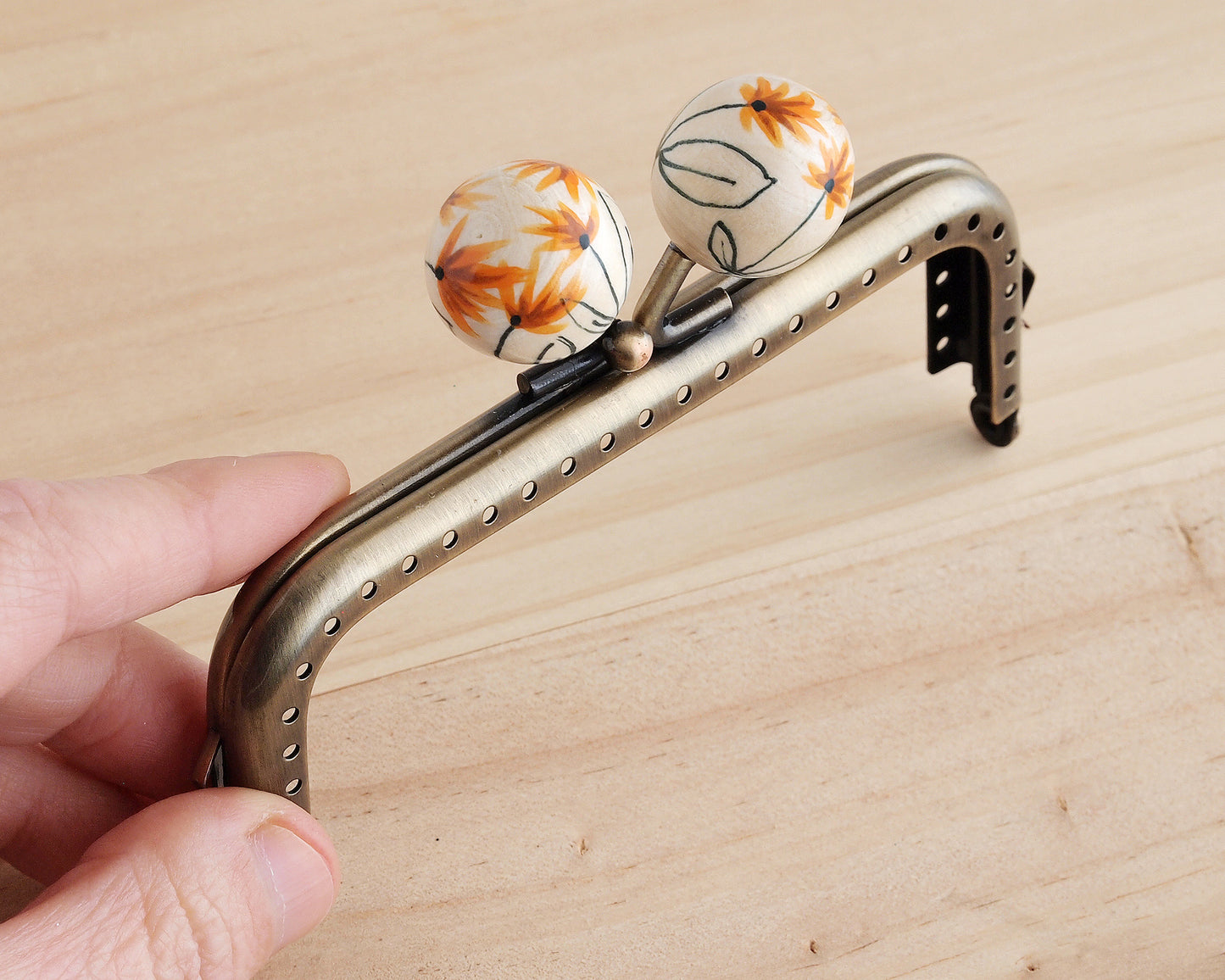 cierre de boquilla para monedero con bolas decoradas a mano con motivos florales
