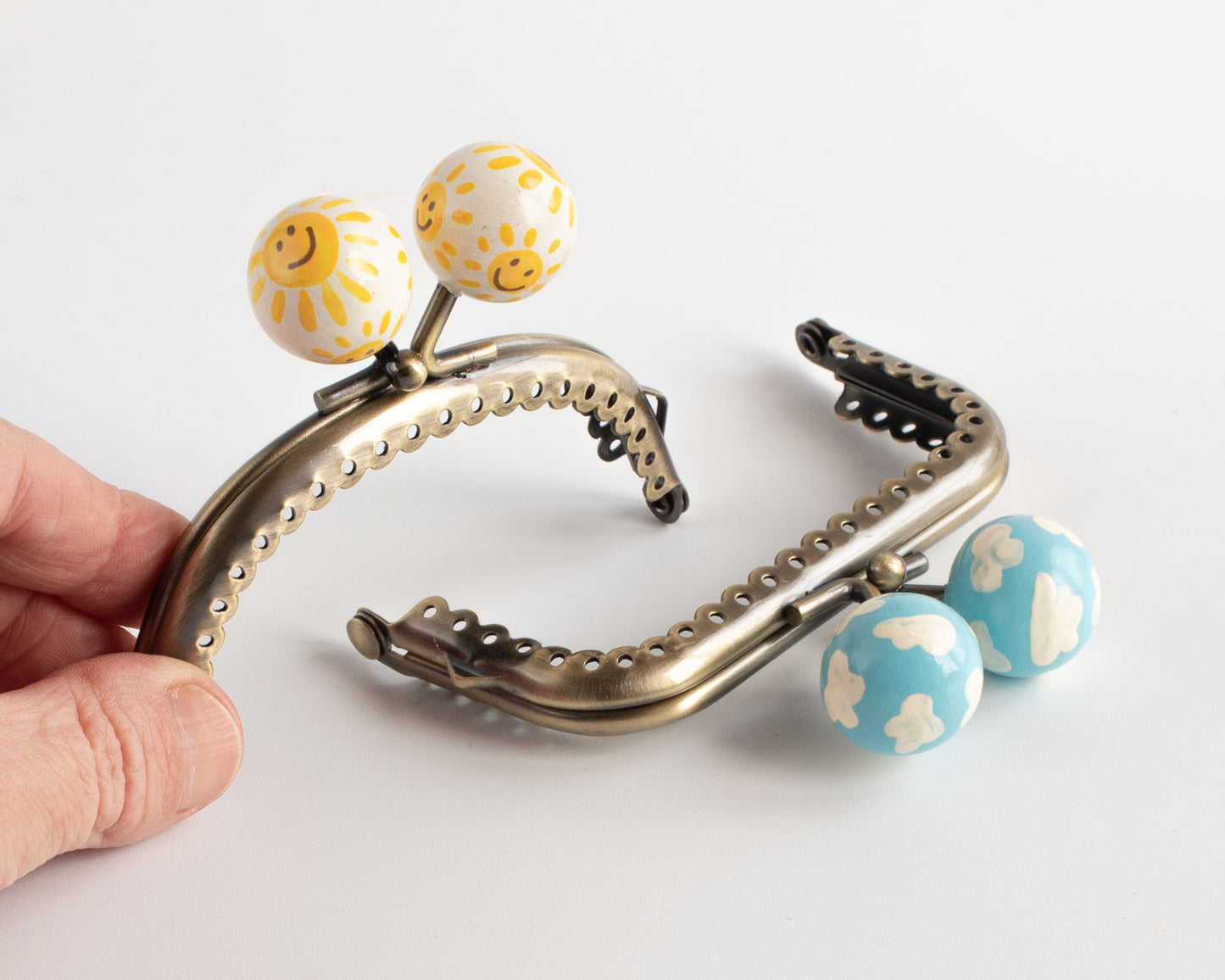 divertidas boquillas para monederos con bolas de madera pintadas a mano con motivos veraniegos de sol y nubes