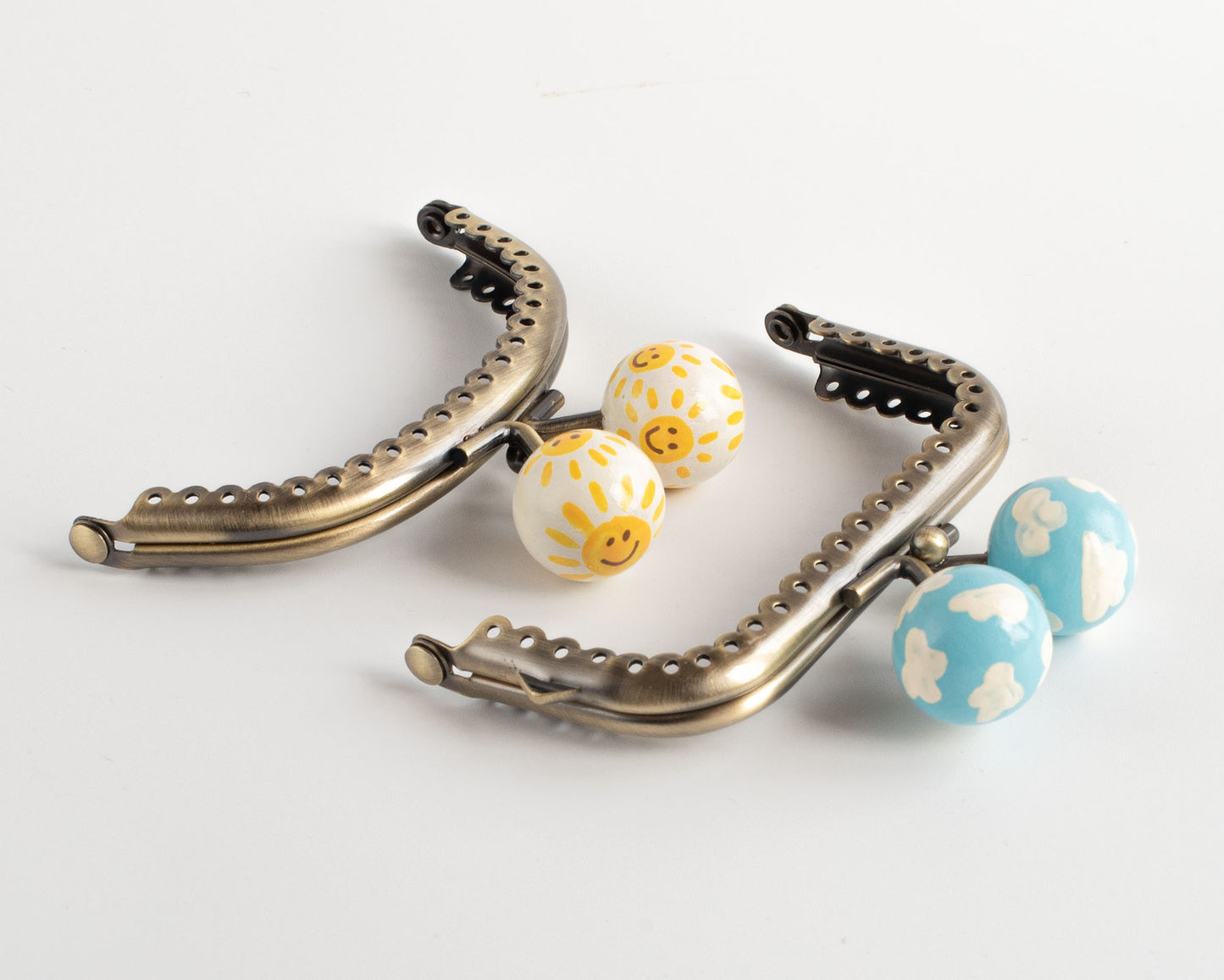 pareja de cierres de boquilla para monederos hechos a mano con soles amarillos que sonrien y nubes blancas sobre cielo azul