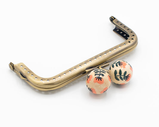boquilla rectangular para monedero con bolas de madera decoradas con motivos florales