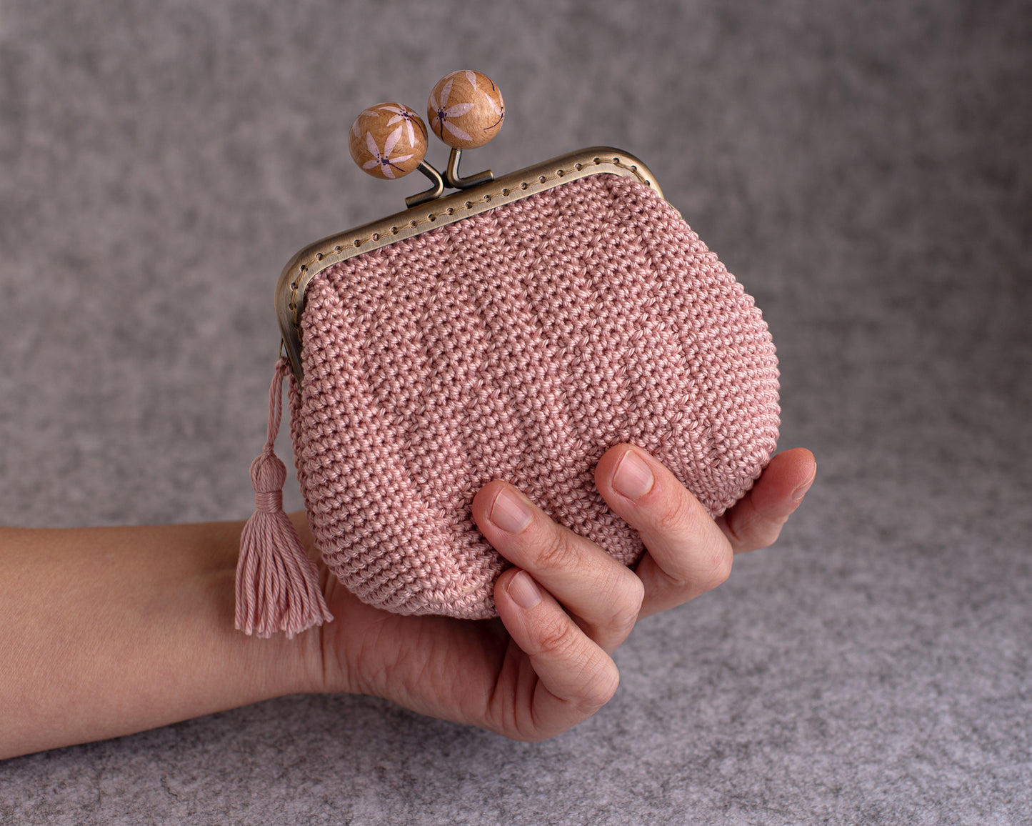 mano que sujeta un monedero de crochet