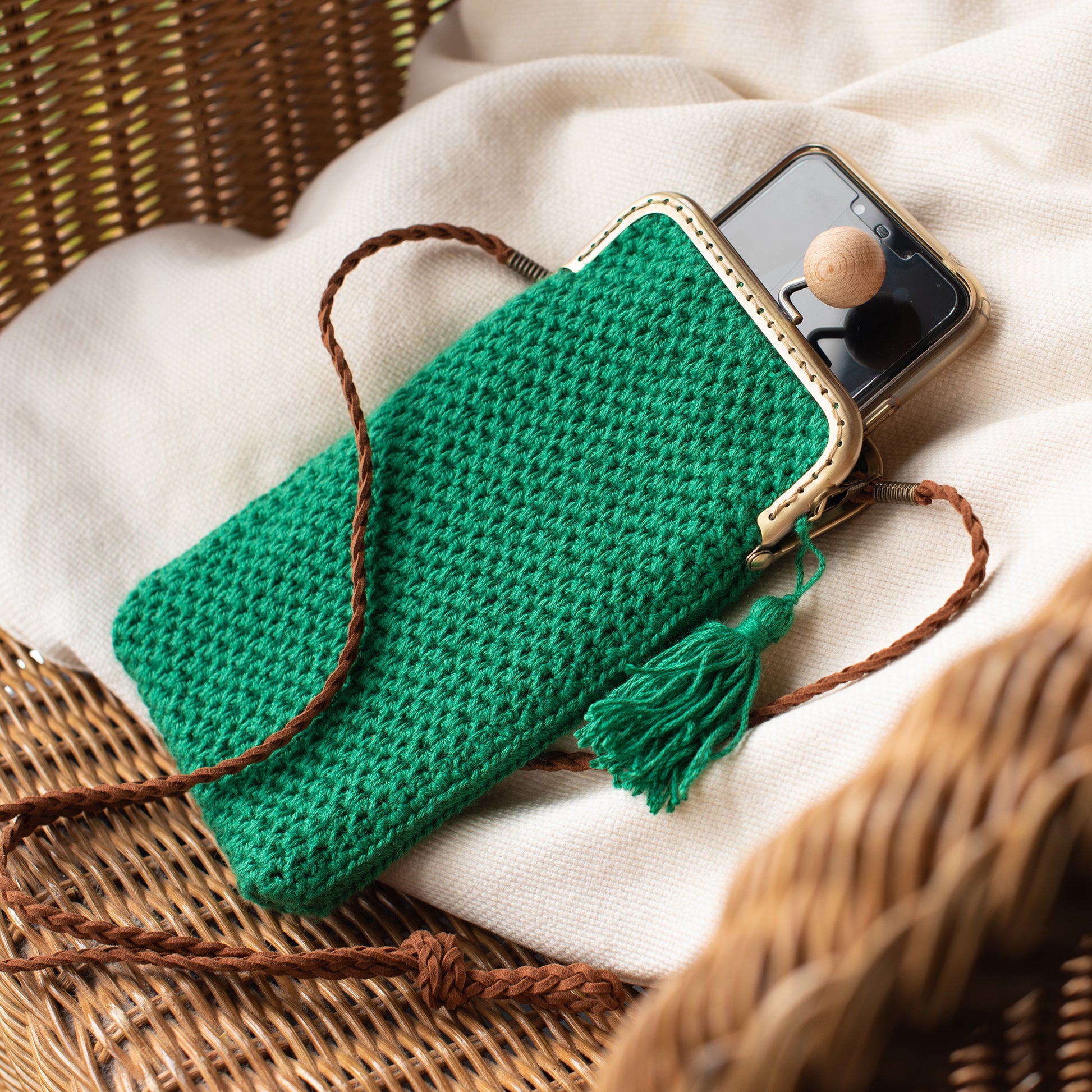 bolso de crochet verde para movil con cierre de boquilla y correa marrón de piel trenzada